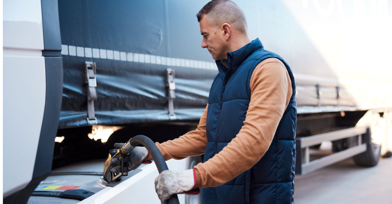 Mann mit Weste betankt LKW.